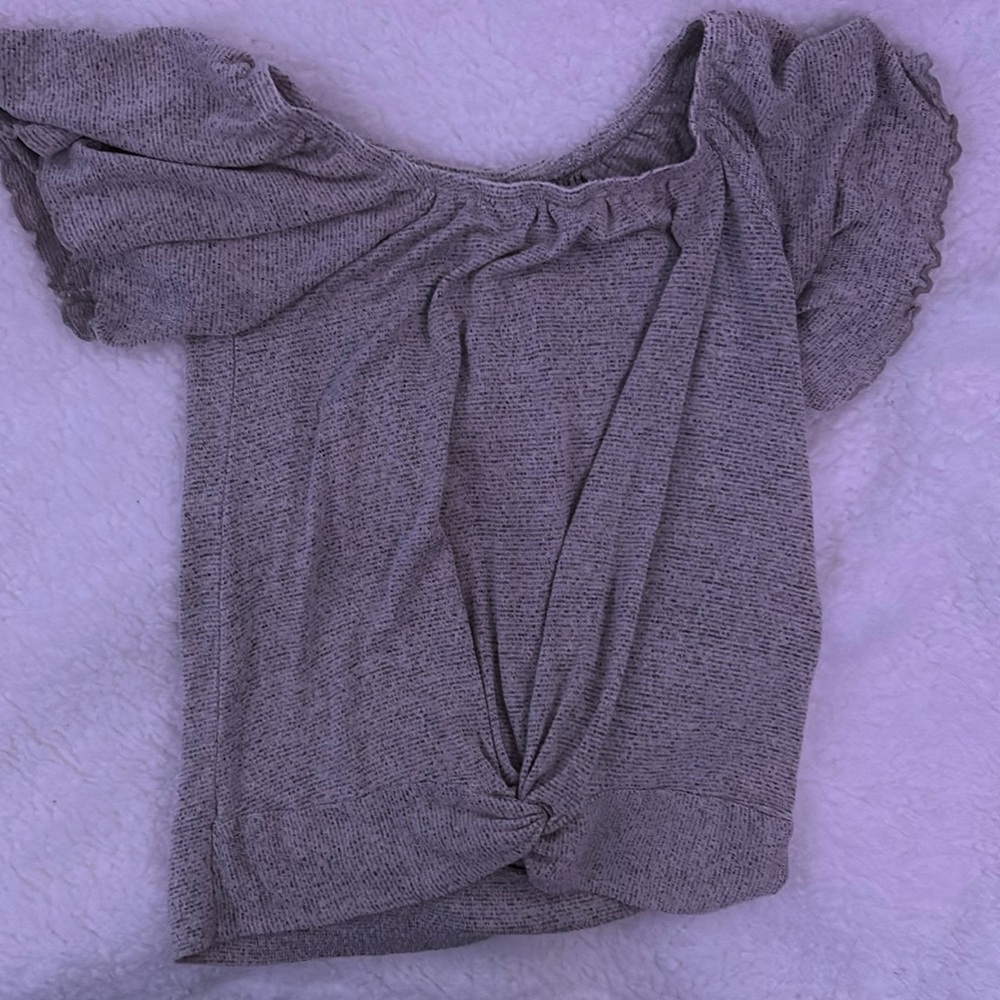 This shirt is gray with ruffles and has a knot on the front which is cute